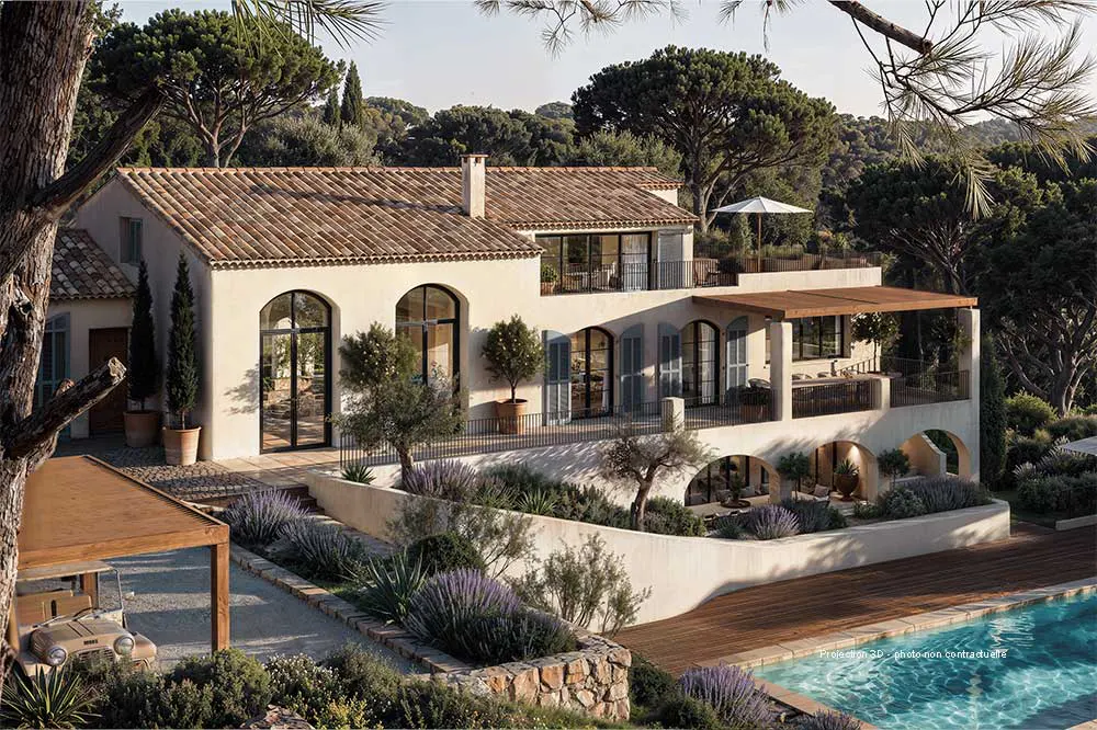 Two-story cream villa with a terracotta tile roof, arched windows, and a pool. Lush greenery surrounds the property.