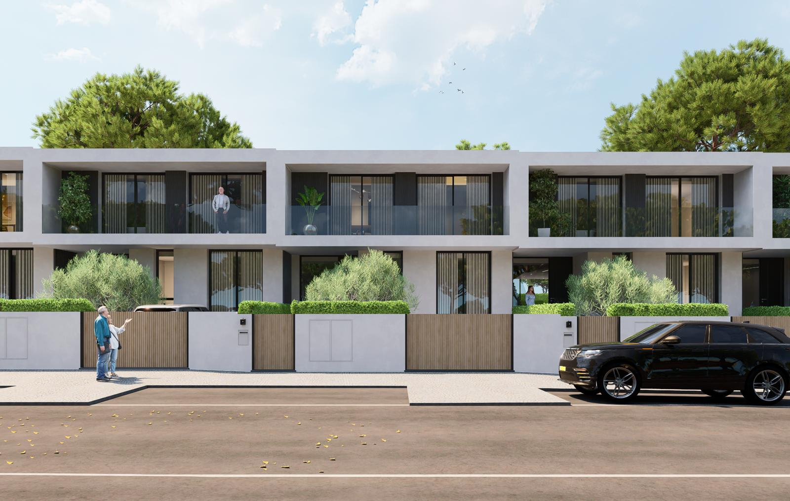 Modern white townhouses with black trim, wood fences, and green shrubbery. A black SUV is parked in front. Two people stand on the sidewalk.