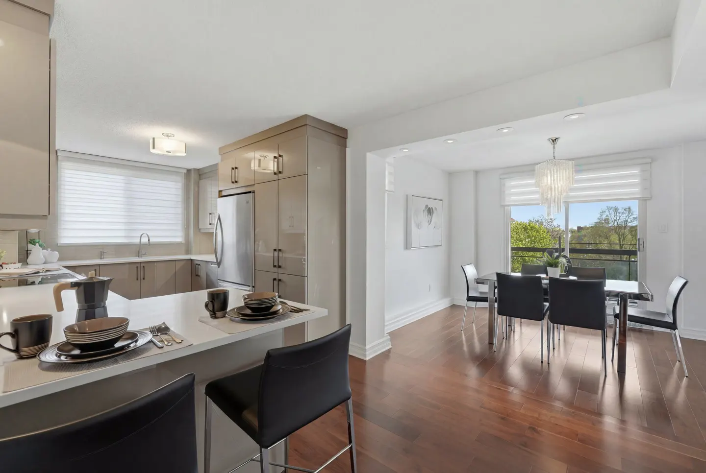 Open concept kitchen and dining area with hardwood floors, stainless steel appliances, and modern decor.