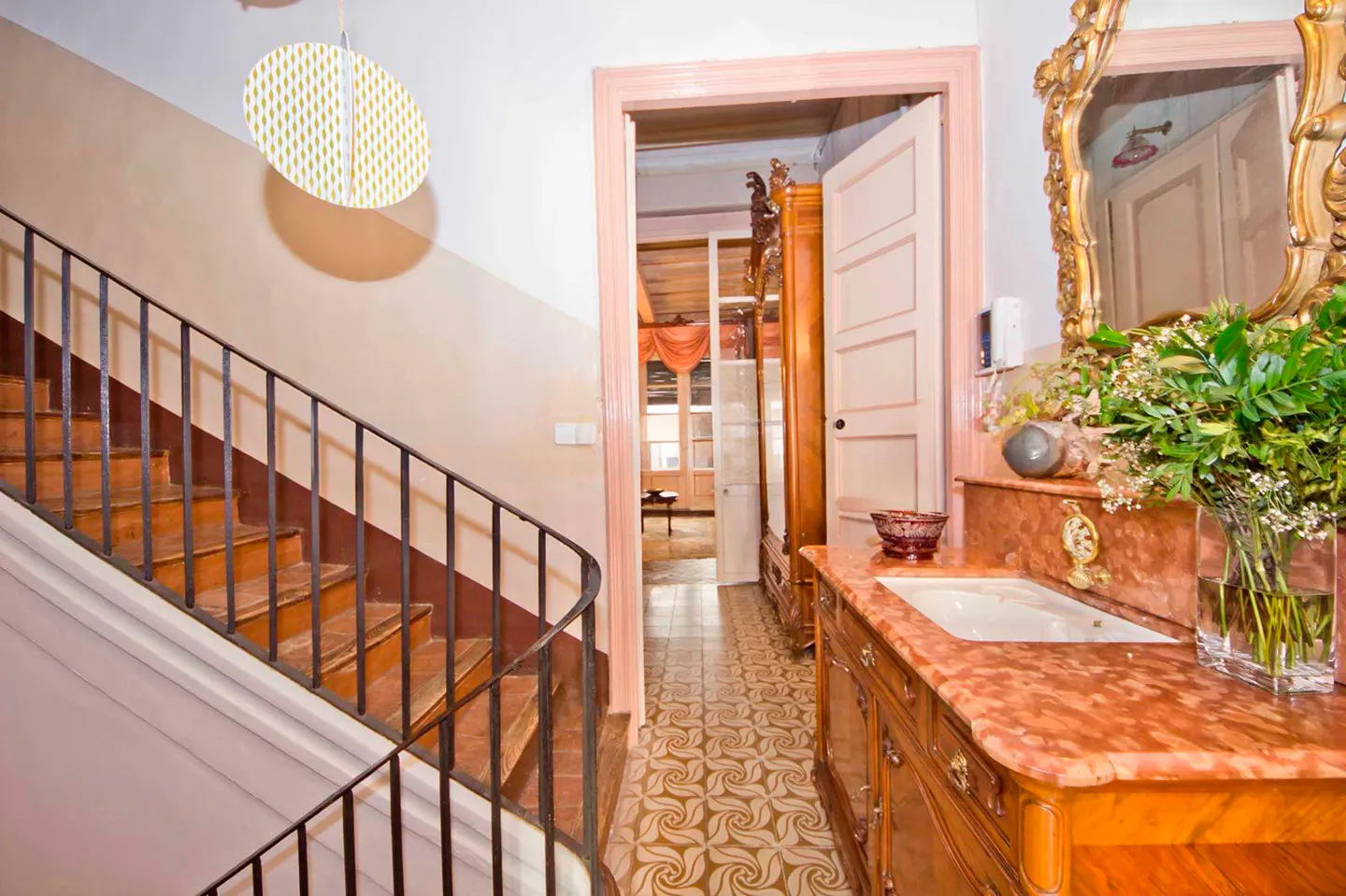 Interior view of a home featuring a staircase, doorway, and vanity with a marble countertop.