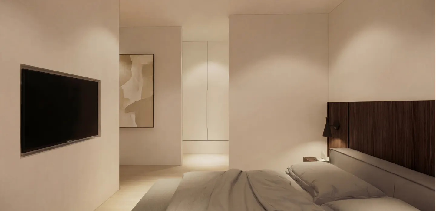 Bedroom with a TV on the wall, a bed with gray linens, and a painting in the background.
