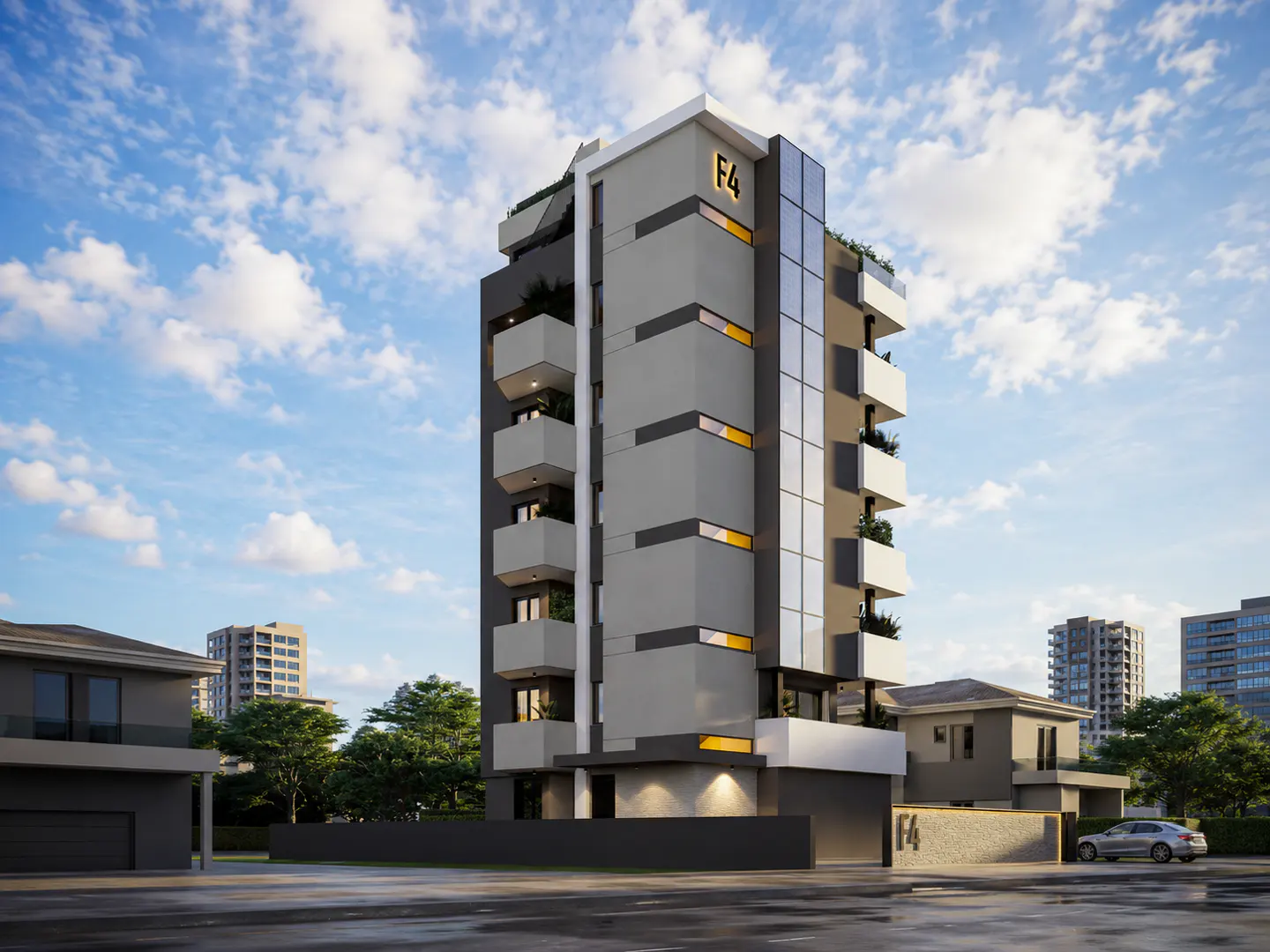 Modern gray apartment building with white balconies and glass accents under a blue sky with clouds.