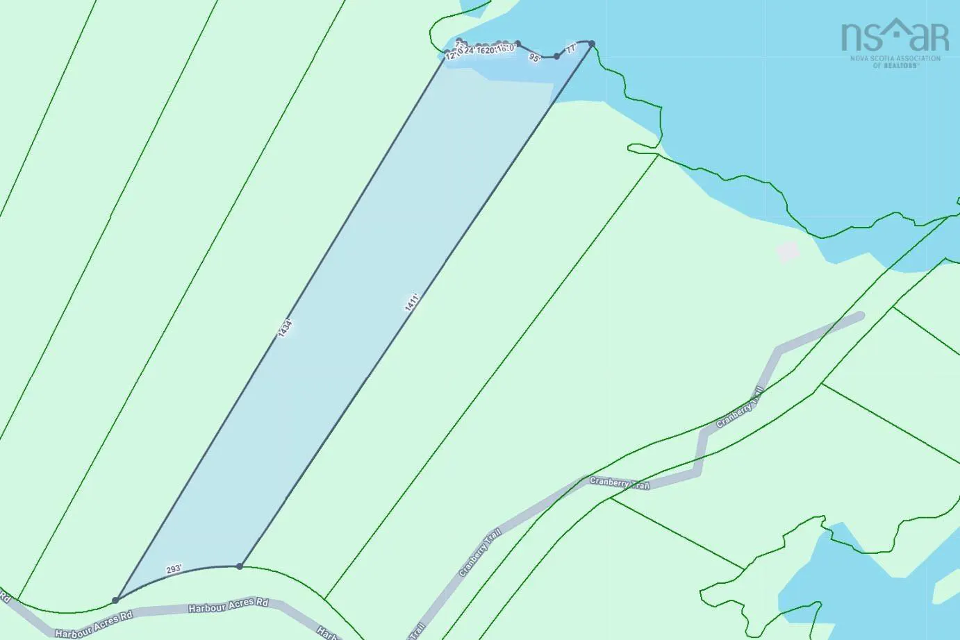 Aerial view of a rectangular property outlined in blue, adjacent to a body of water. Roads and land boundaries are visible.