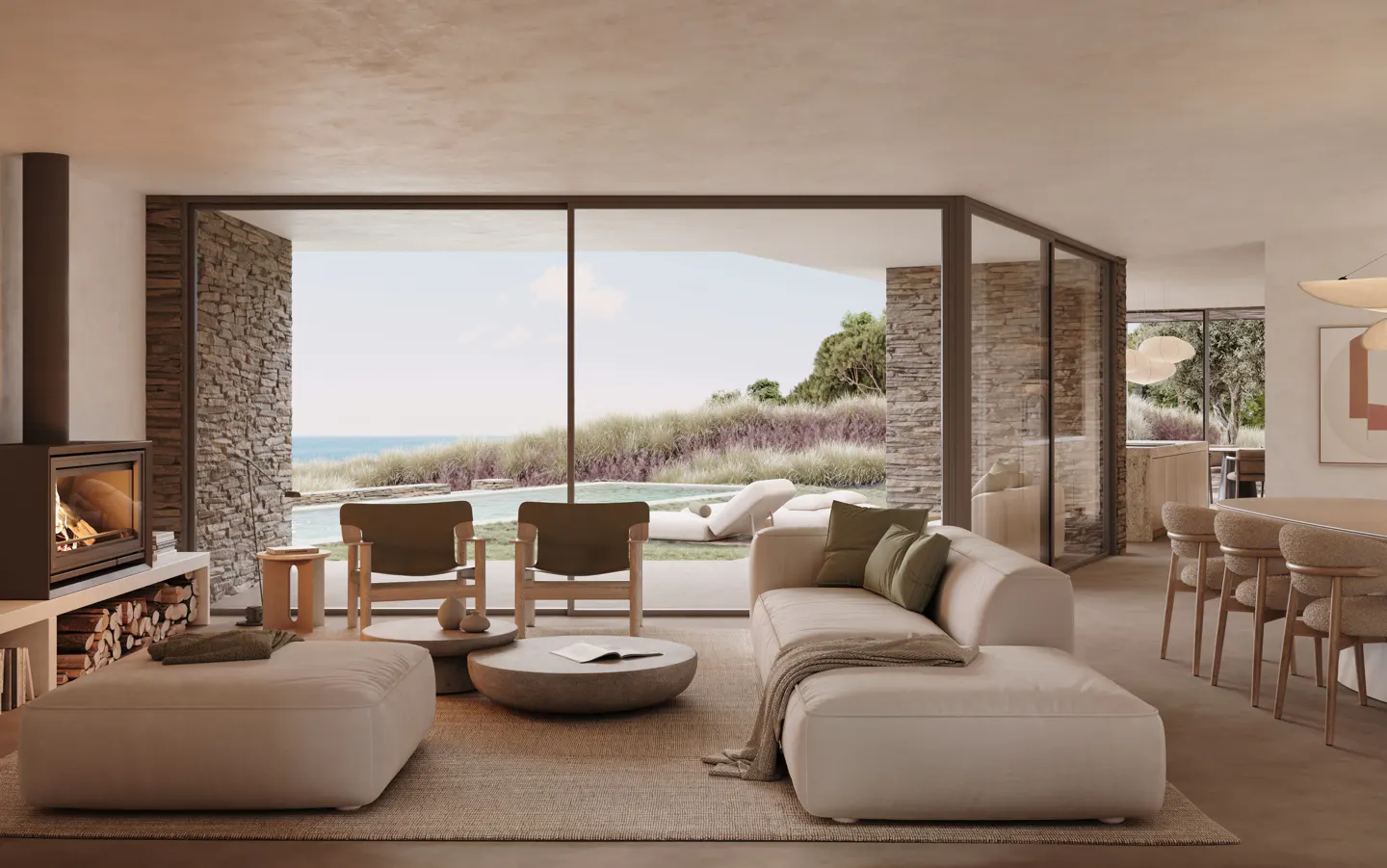 A bright living room with a fireplace, a beige sofa, and a view of the ocean.