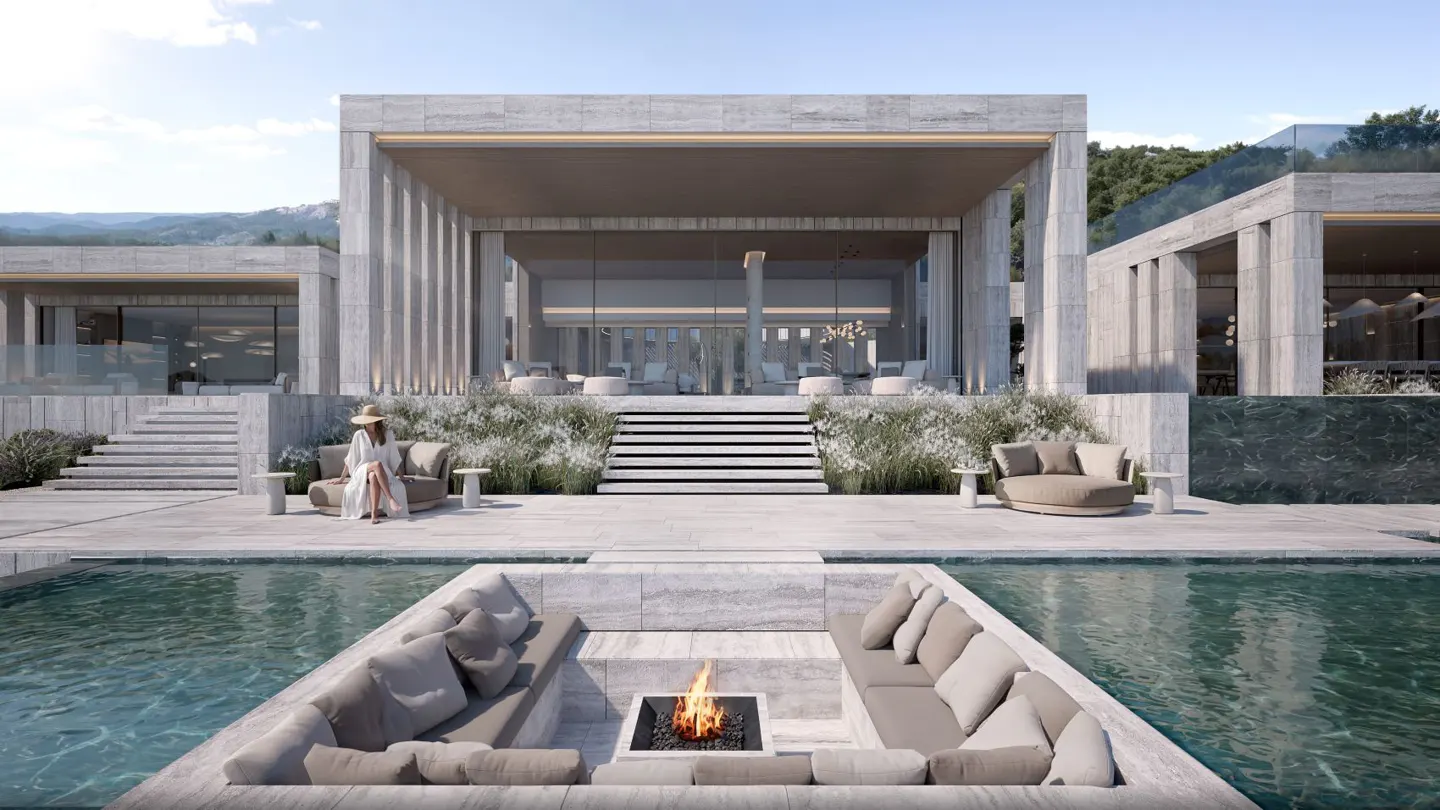 Luxury villa with pool and sunken fire pit. A woman sits on a sofa. The villa is modern with stone columns and large windows. Mountains are in the background.