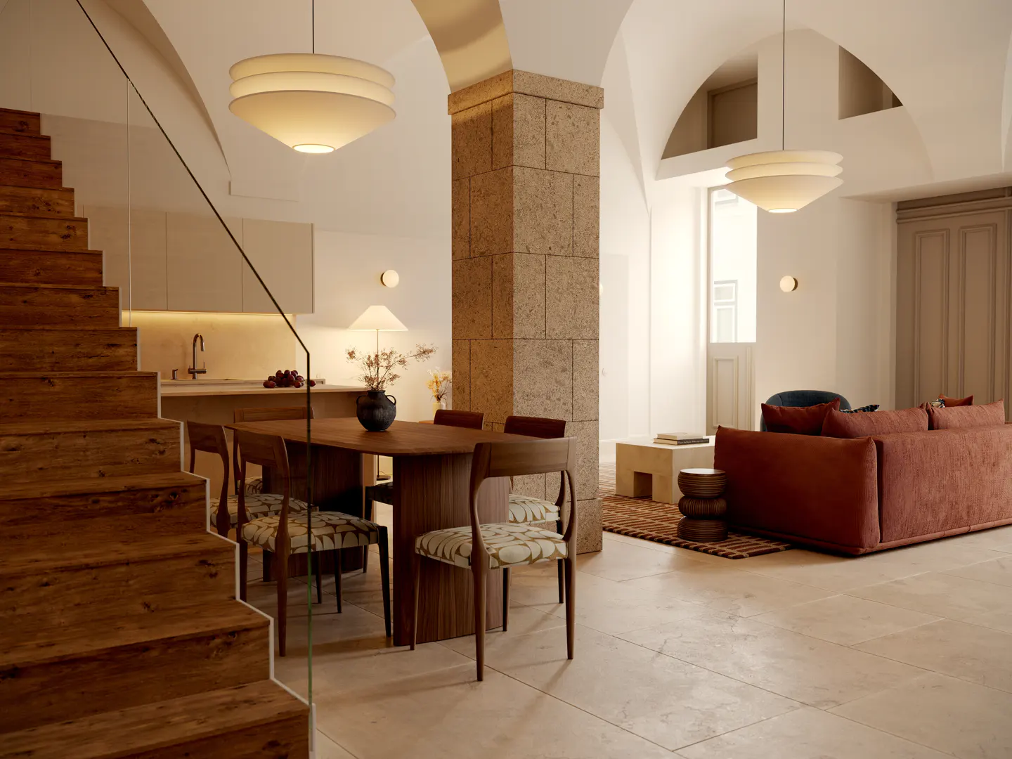 Bright, open-plan living space with wood stairs, dining table, and rust-colored sofa under arched ceilings.
