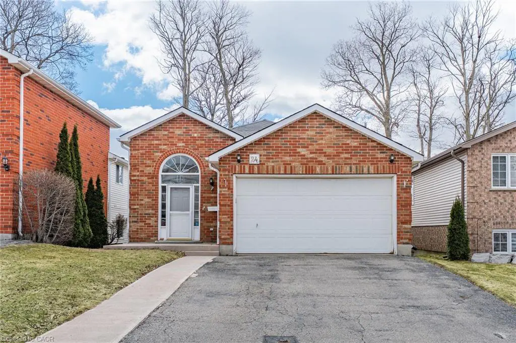 Red brick house with white garage door and arched front door. Trees in the background.