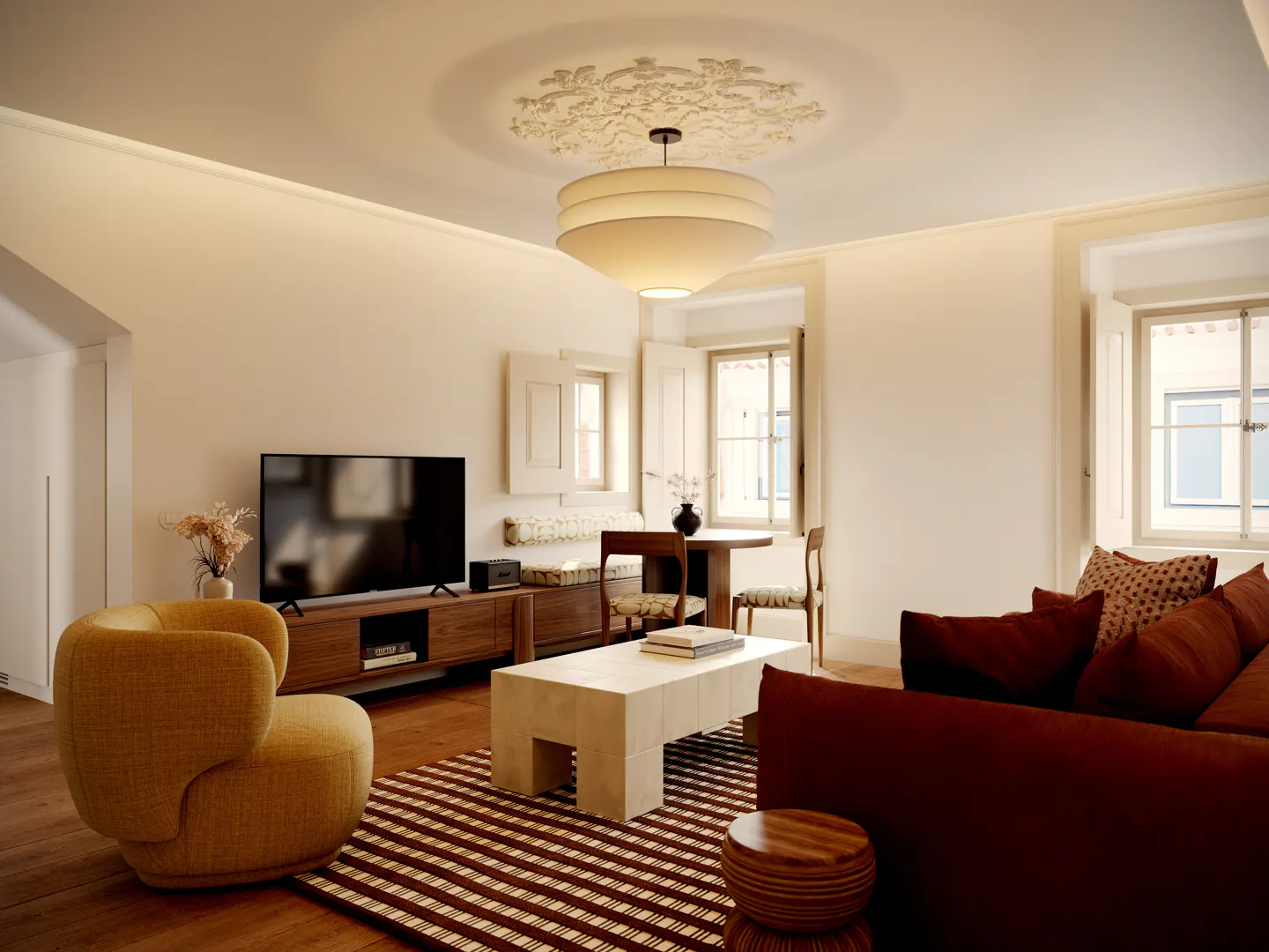 Living room with a yellow chair, brown sofa, striped rug, and a TV on a wooden stand. Windows with white shutters let in natural light.