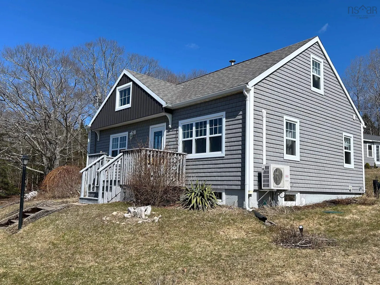 Exterior view of a gray, two-story house with white trim, a gray roof, and a small porch with stairs.
