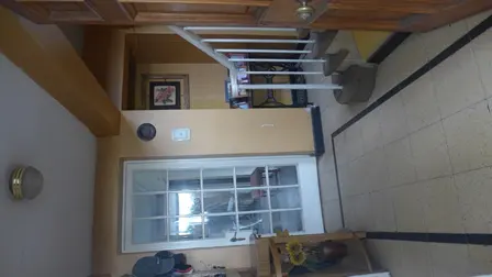 Interior view of a home featuring a white staircase, tiled floor, and a window with natural light.