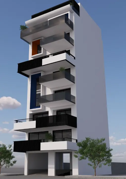 Modern white apartment building with black balconies and blue and orange accents against a blue sky.
