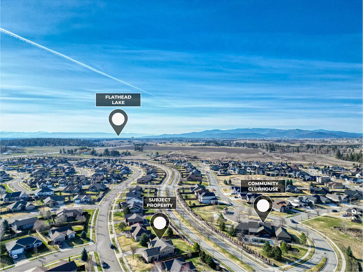 Aerial view of a residential area under a blue sky, with markers for "Subject Property," "Community Clubhouse," and "Flathead Lake."