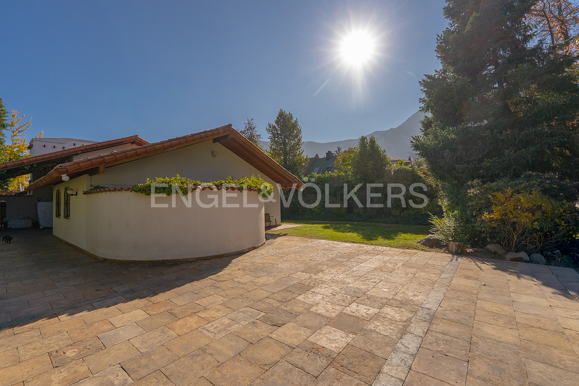 Casa  con jardín plano y vistas al cerro Manquehue.