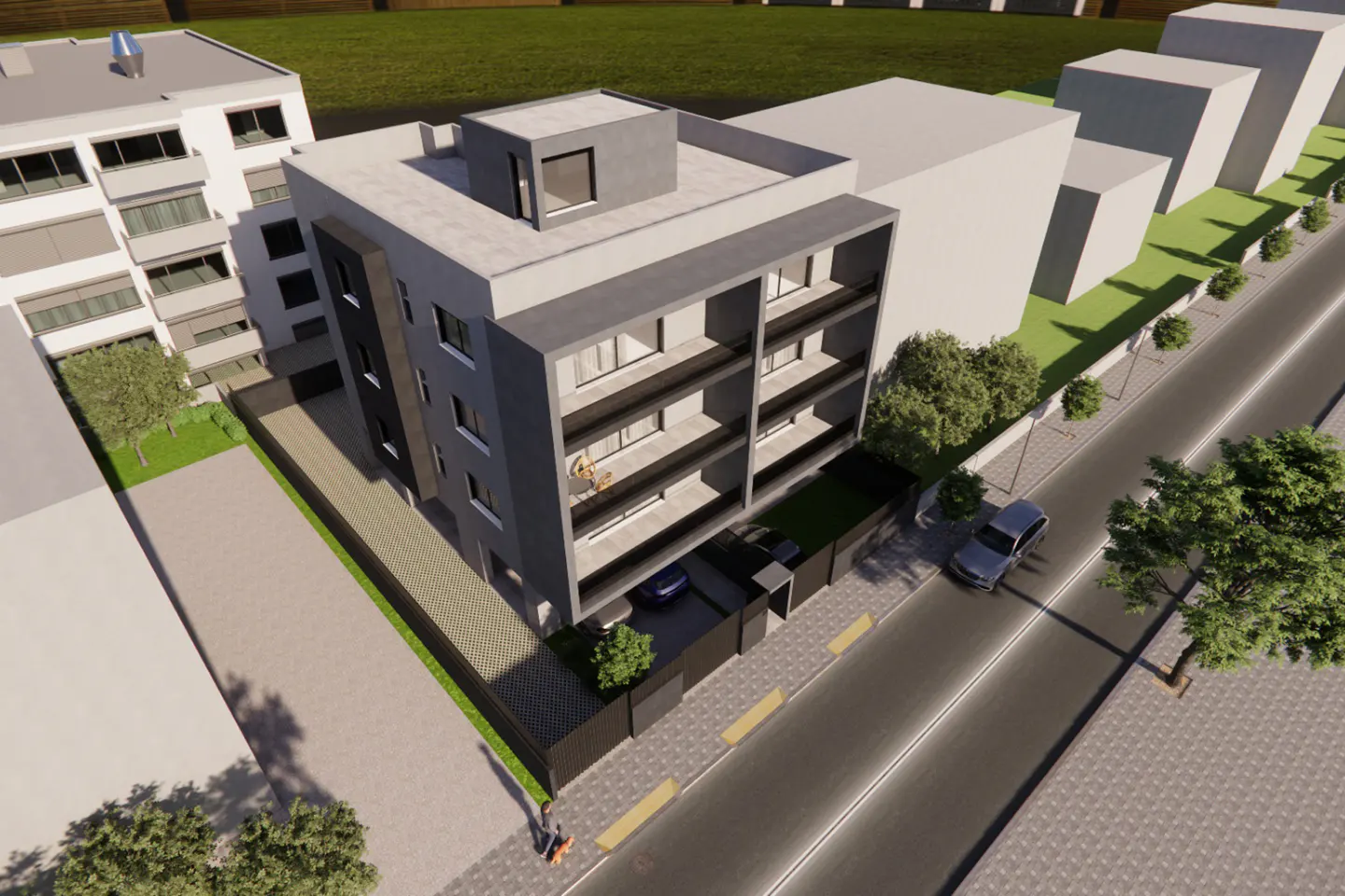 Aerial view of a modern, gray apartment building with balconies, cars parked below, and a street with trees.