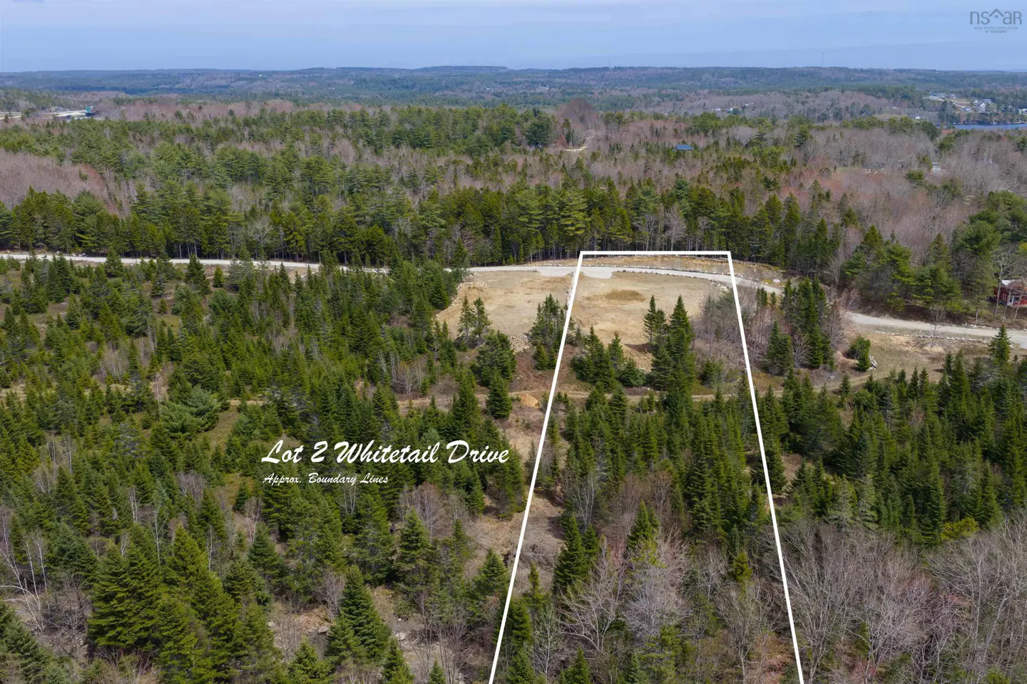 Aerial view of Lot 2 Whitetail Drive, a cleared plot surrounded by green trees, marked with white boundary lines.