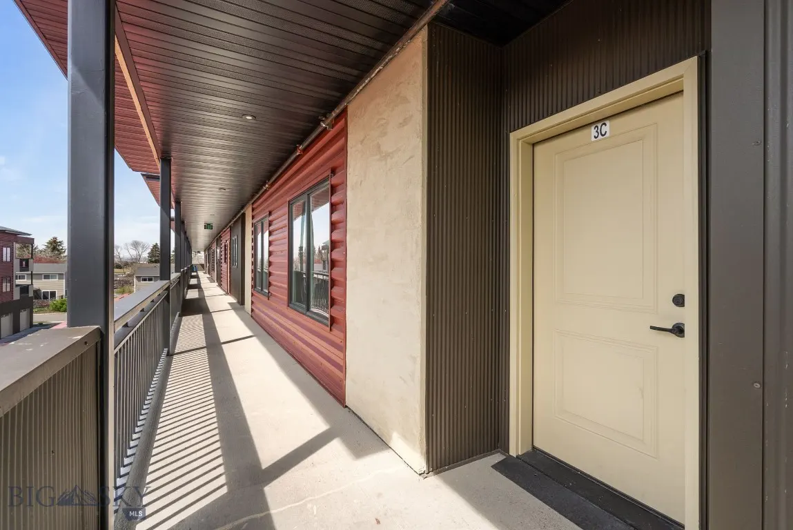 Exterior hallway with a metal railing, red siding, and a beige door labeled "3C".