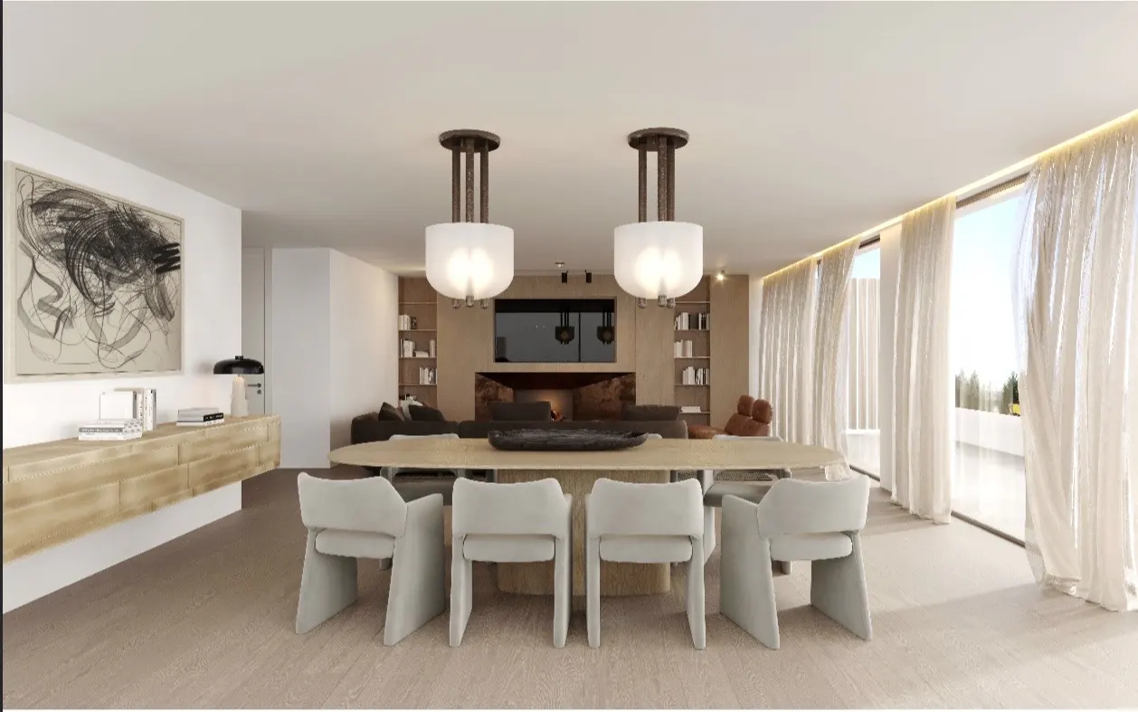 A bright, modern living and dining area with a long table, white chairs, and two pendant lights. A fireplace and bookshelves are in the background.
