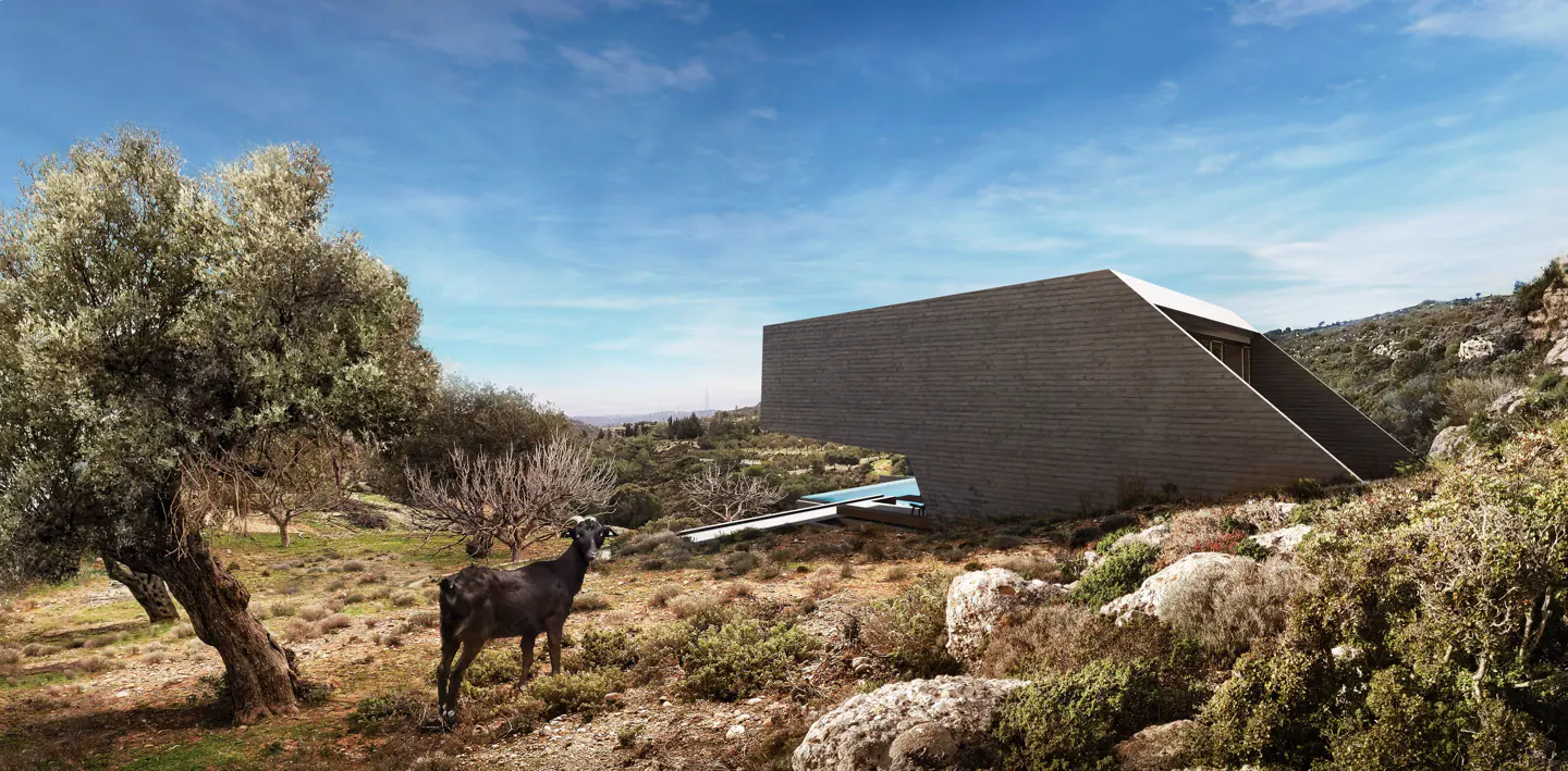 Modern gray house with a pool, nestled in a rocky landscape. A black goat stands in the foreground near a tree. Blue sky.