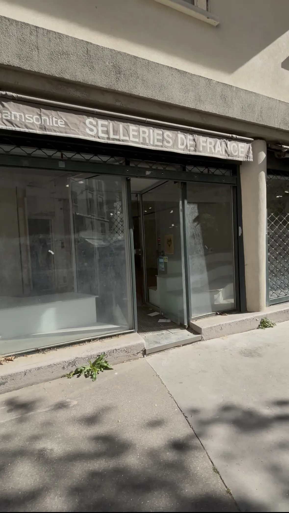 Storefront of "Selleries de France" with glass windows and a partially open entrance. The building is light gray.