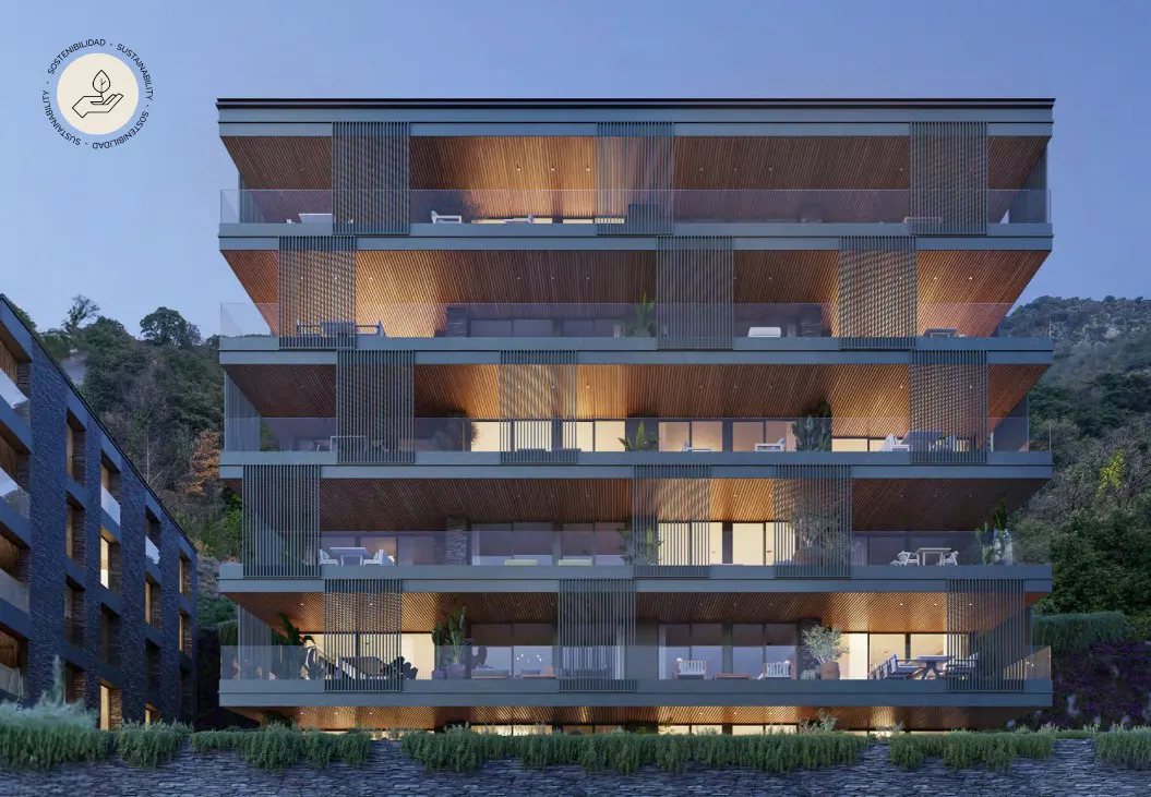 Modern apartment building with balconies and wood accents, set against a backdrop of lush greenery and a mountain.