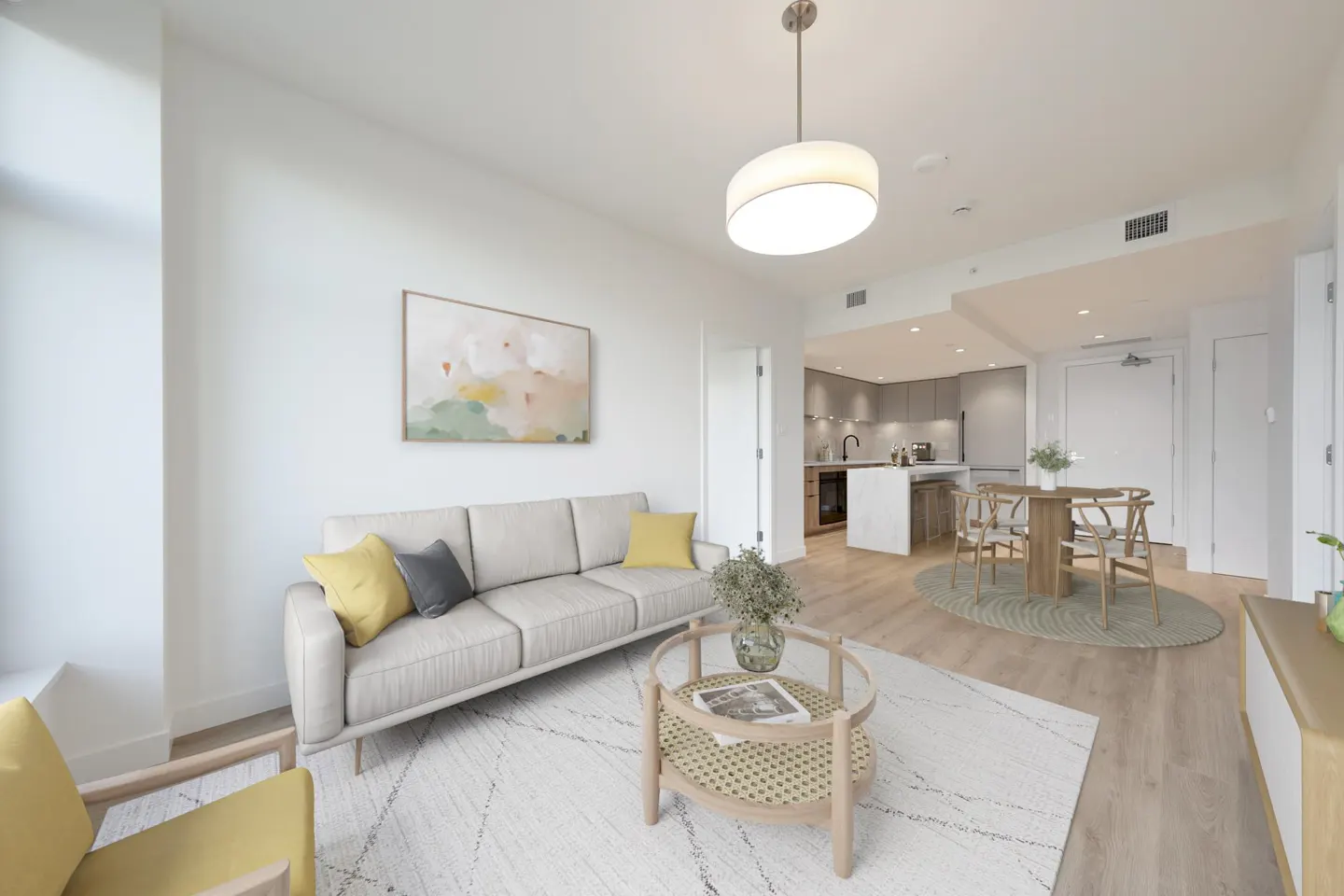 Bright, modern apartment interior with a beige sofa, round coffee table, and open kitchen. An abstract painting hangs above the sofa.