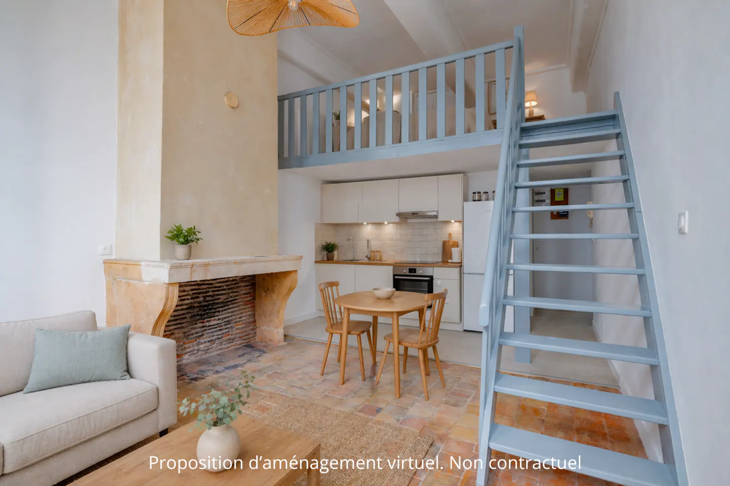 Cozy apartment interior with a stone fireplace, a small kitchen, and a blue staircase leading to a loft area.