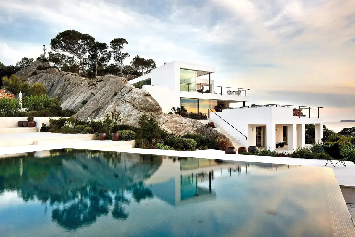 Modern house with a pool built against rocky terrain