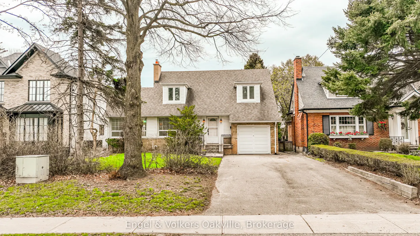 Exterior view of a white, single-family home with a gray roof, white garage door, and a concrete driveway.
