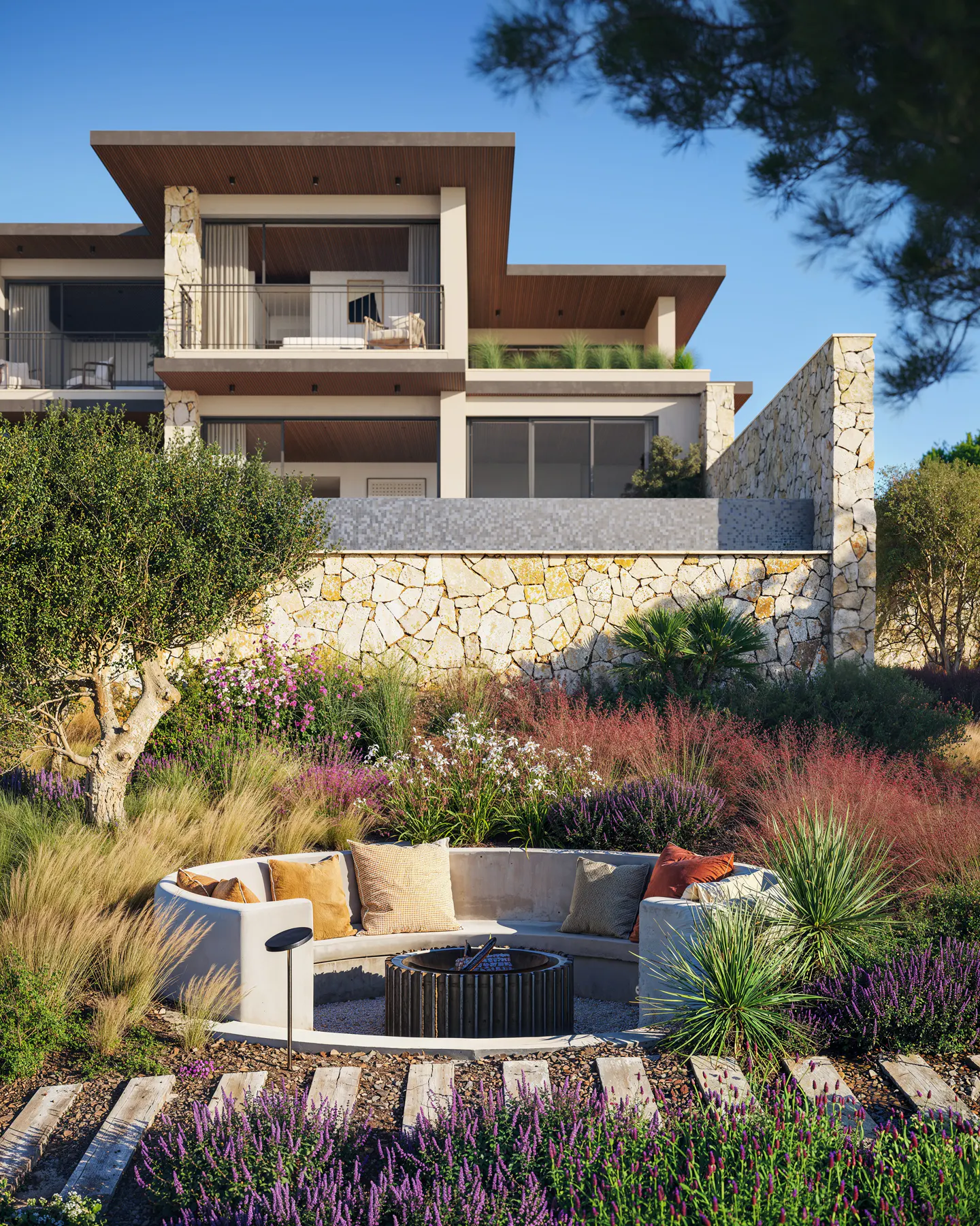 Modern two-story house with a stone wall and a circular outdoor seating area with a fire pit. Cushions add comfort to the built-in seating.