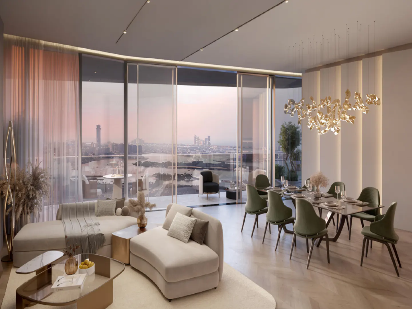 Open-concept living and dining area with floor-to-ceiling windows overlooking a city skyline at sunset. Beige sofas and green chairs.