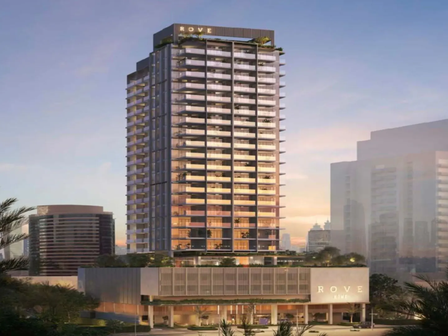 Exterior view of the Rove Home skyscraper with glass balconies and a modern design against a blue sky.