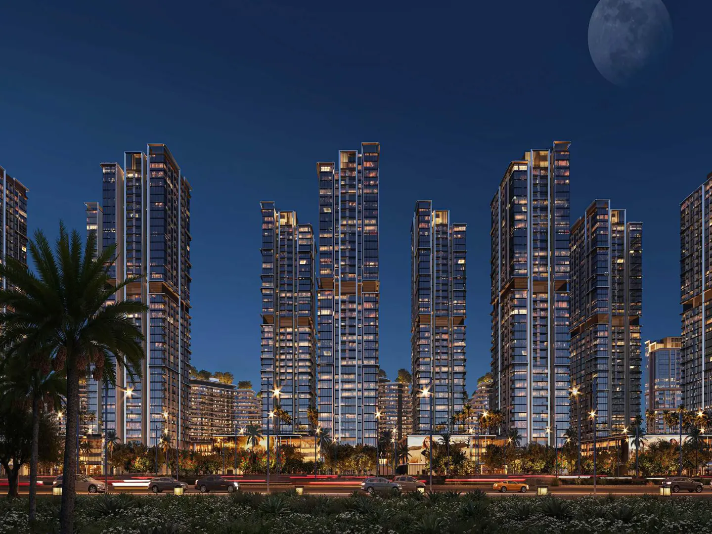 Night view of modern high-rise buildings with illuminated windows, palm trees, and a full moon in the dark blue sky.