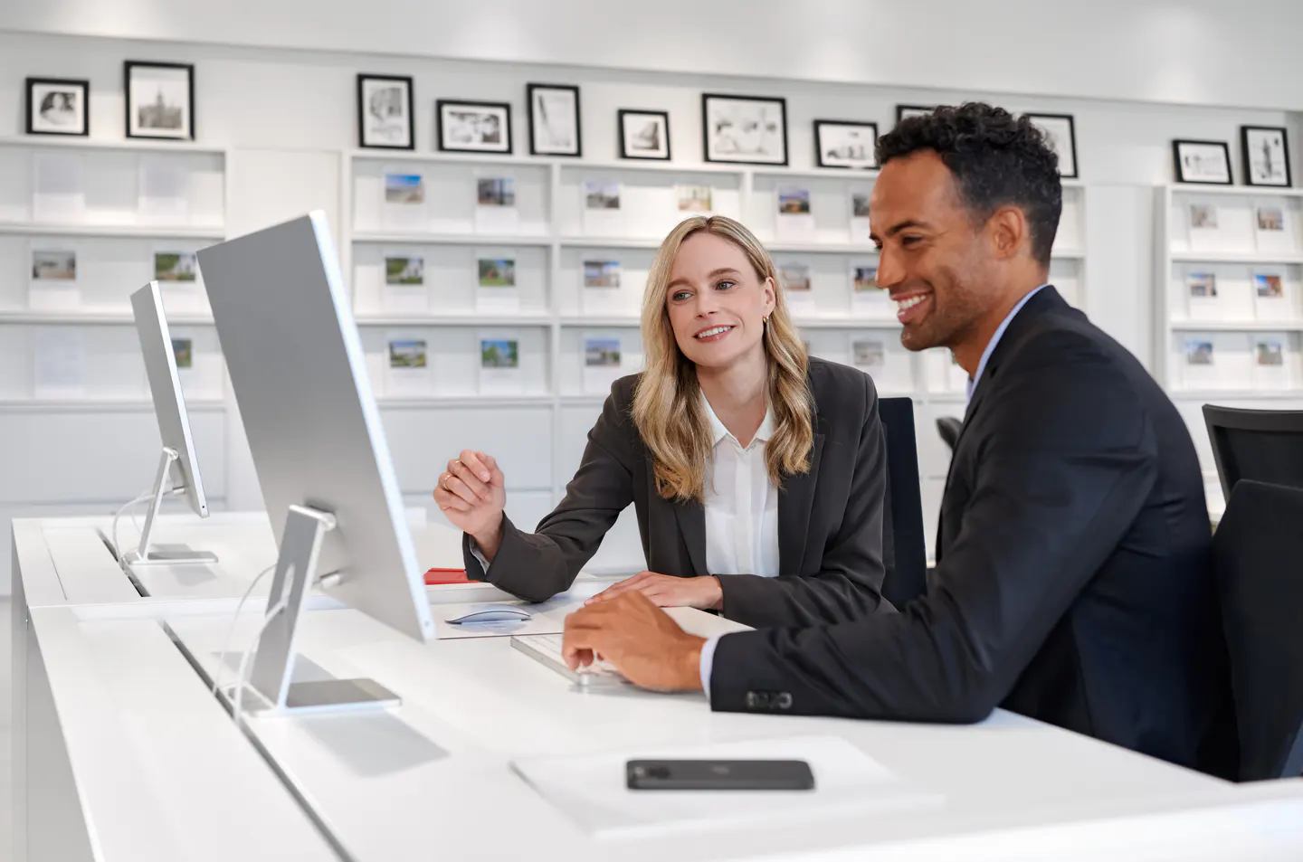 Real estate agent advising a client at a desk