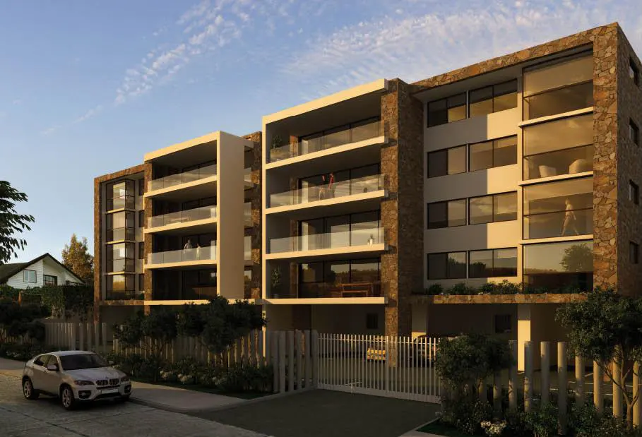 Modern apartment building with stone accents, glass balconies, and large windows. A silver car is parked in front.