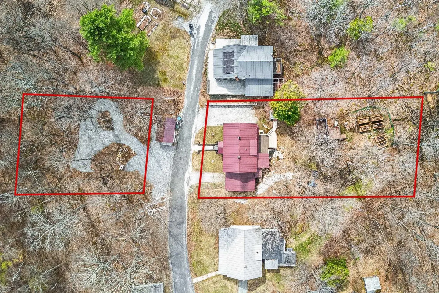 Aerial view of a property with two houses, a shed, and two lots outlined in red.