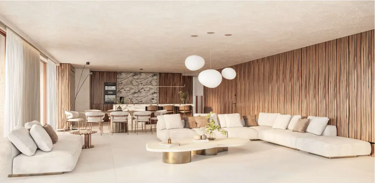 A modern living room with a white sectional sofa, wood-paneled walls, and a marble kitchen island.