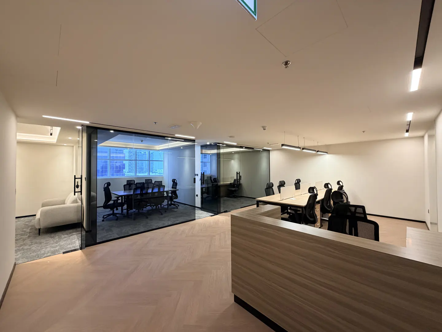 Office space with a reception desk, conference room with a table and chairs, and open work area with desks.