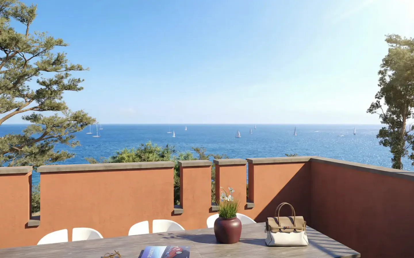 Terrace view of the ocean with sailboats. Table with purse, flowers, and book. Orange wall, blue sky, and green trees.