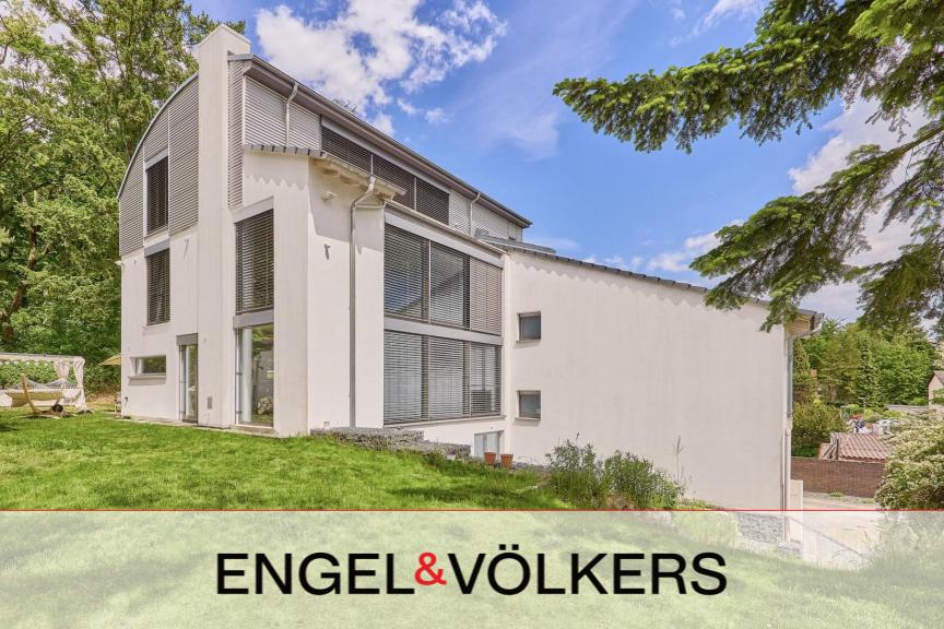Modern white multi-story home with large windows and gray accents, set in a lush green yard under a bright blue sky. [AI-generated text]