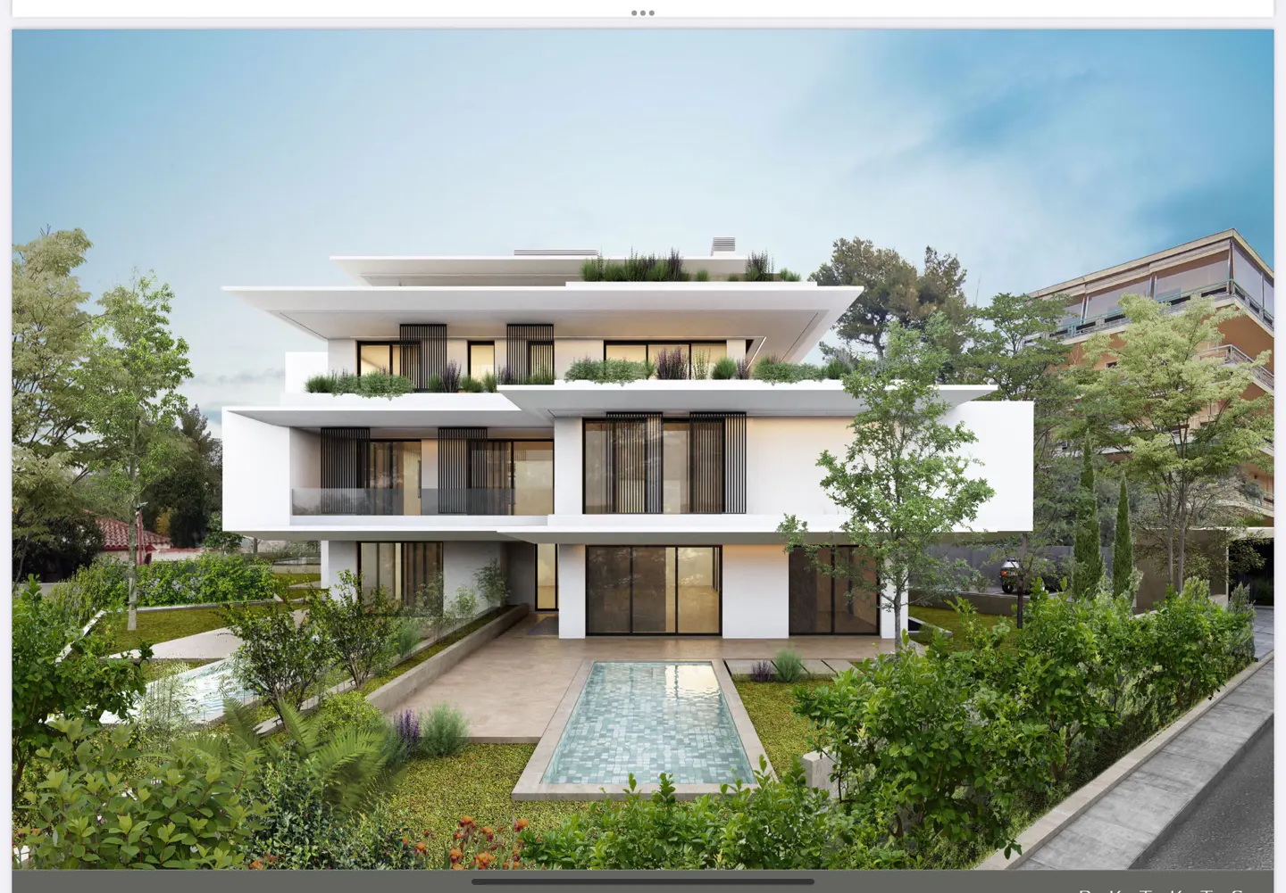 Modern three-story white house with a flat roof and large windows. A rectangular pool is in the front yard, surrounded by green plants.