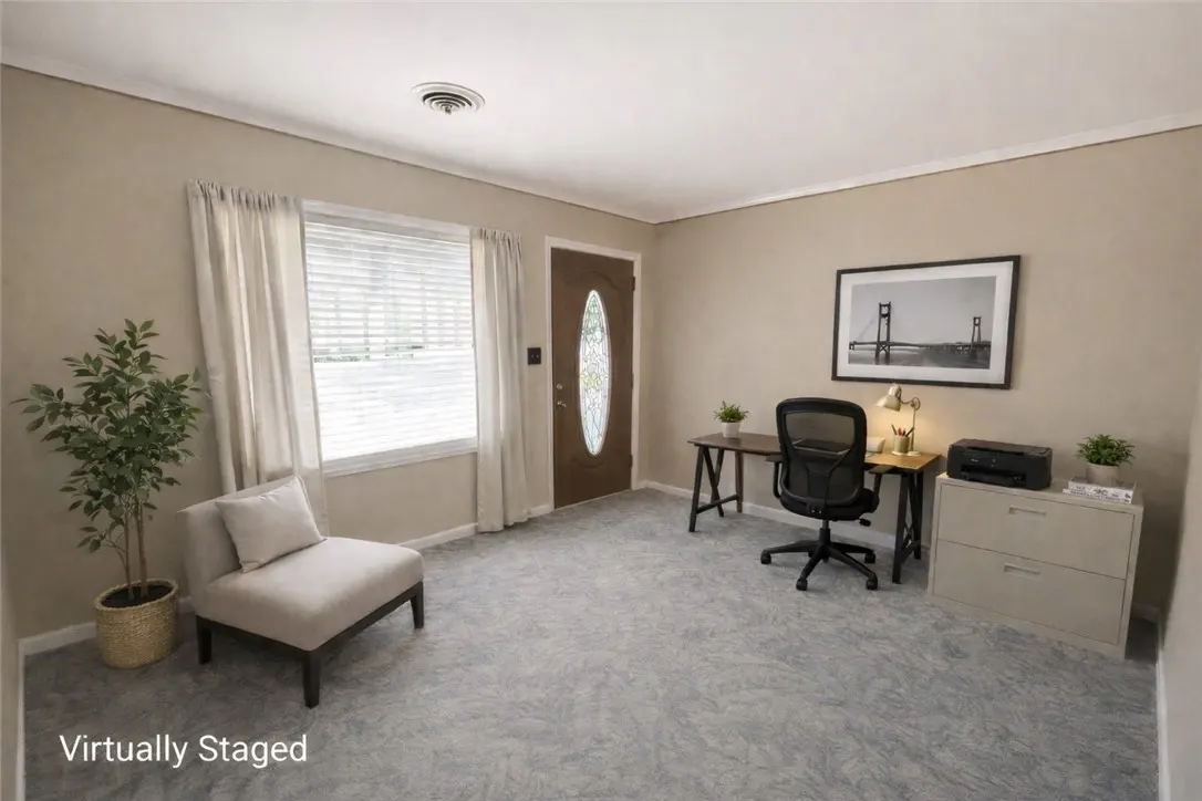 A staged room with a desk, chair, filing cabinet, and a chair with a plant.