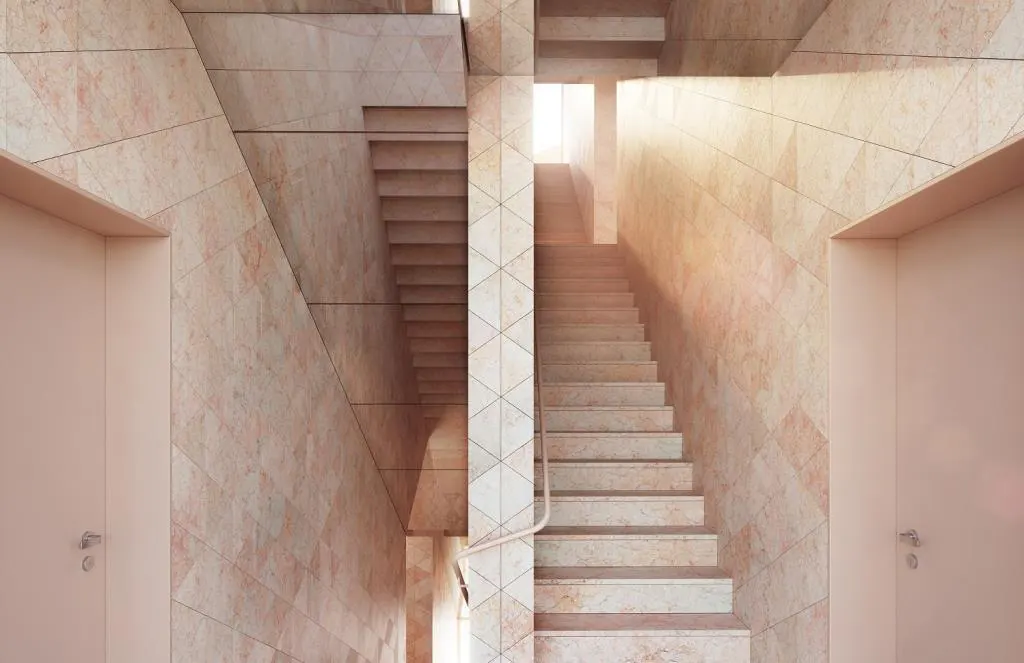 Interior view of a staircase with marble walls and two closed doors on either side. Sunlight streams in from the top of the stairs.