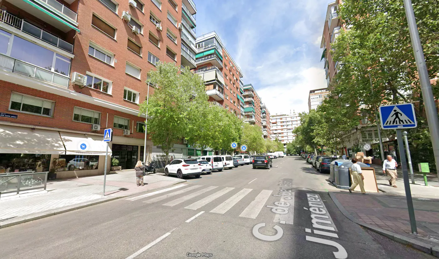 Street view of C. de Julián Jiménez in Madrid, Spain. Brick buildings line the street with parked cars and pedestrian crosswalks.