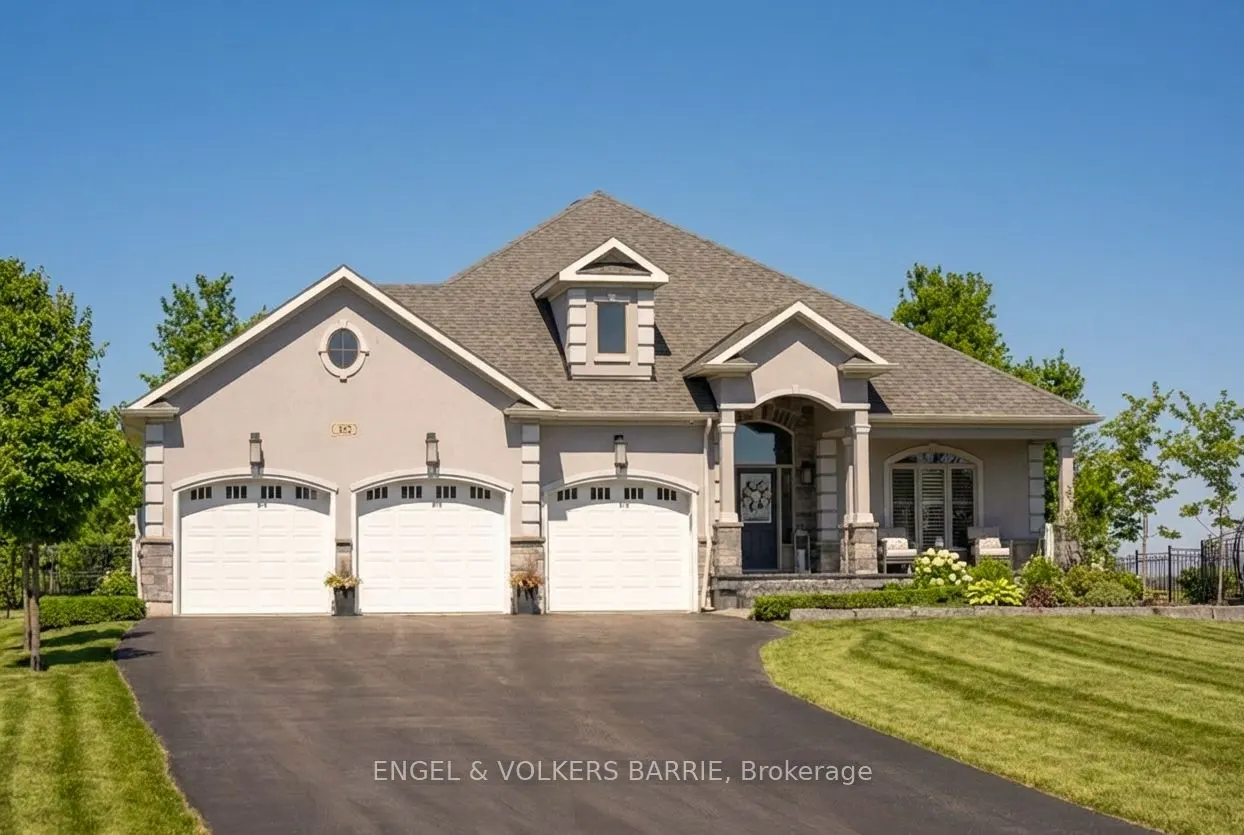 Beige single-story house with a gray roof, three-car garage, and a dark driveway on a sunny day.