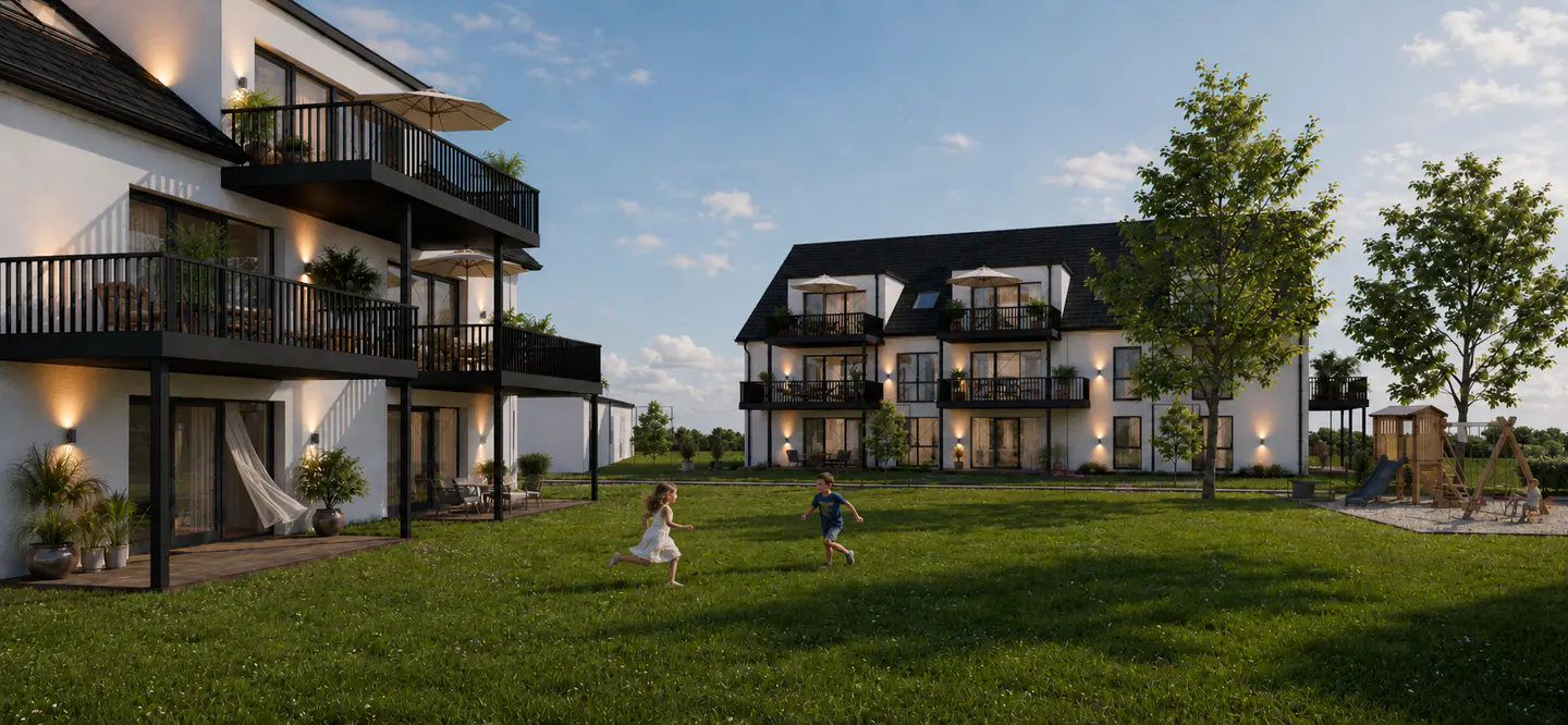 Two children run on the lawn of a modern, white apartment building with black balconies and a playground in the background.