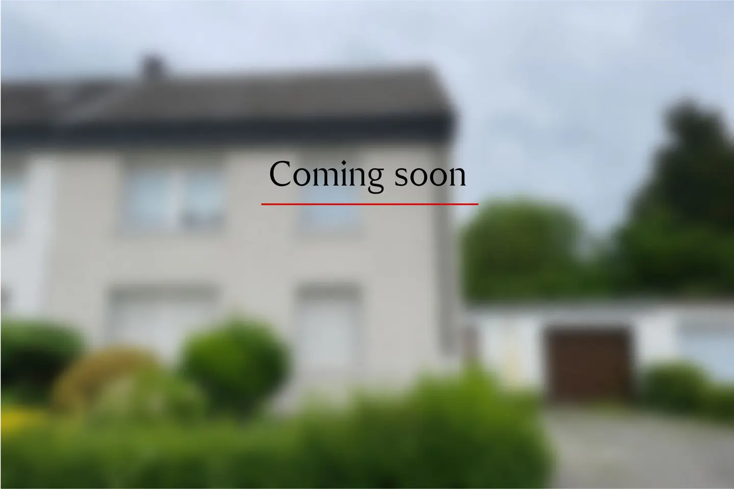A blurred image of a light-colored house with a dark roof and a garage, featuring the text "Coming soon" in the center.