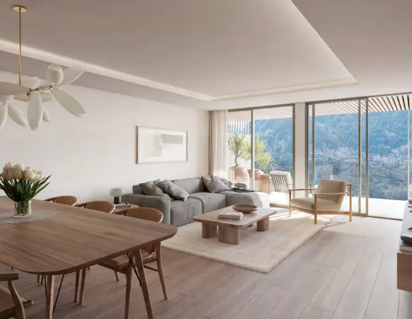 Bright, modern living room with a wood dining table, gray sofa, and large windows overlooking a mountain view.