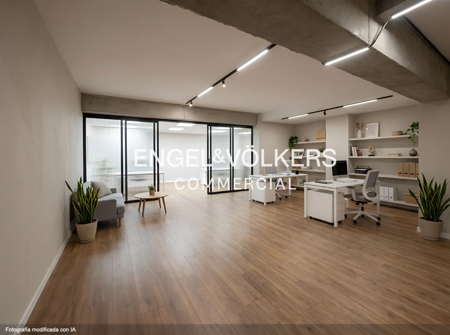 Bright office space with wood floors, white desks, and a gray sofa. Engel & Völkers Commercial logo is displayed.