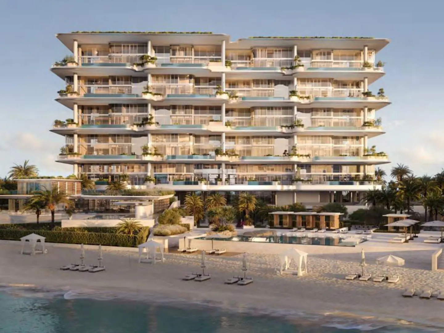 Luxury beachfront condo building with pools on each balcony, palm trees, and white sand.