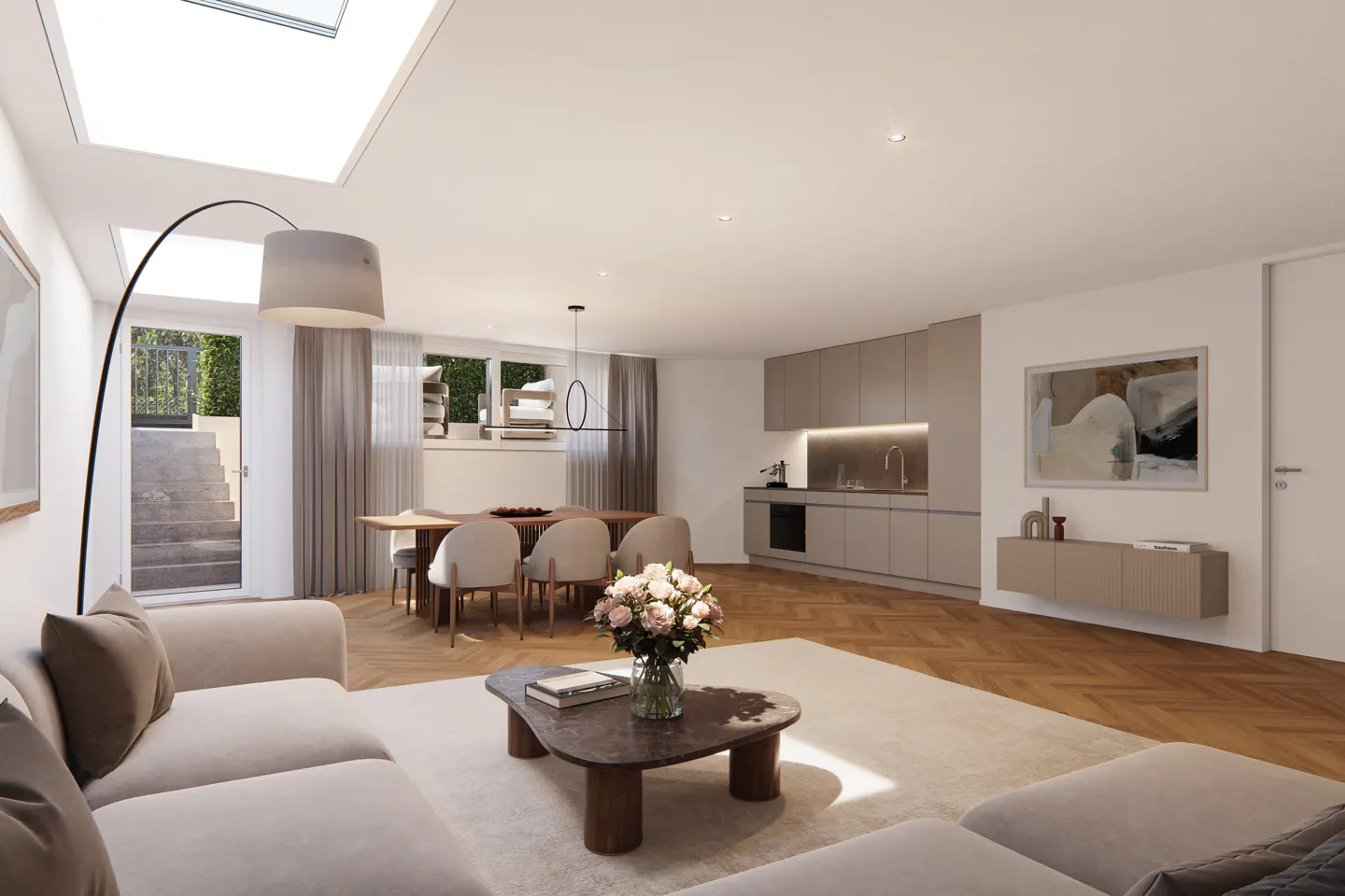 Open-concept living space with a beige sofa, wood floors, dining table, and kitchen. A skylight provides natural light.